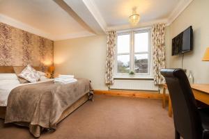 a bedroom with a bed and a desk and a window at Hambleton House in Derby
