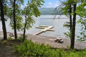 a wooden dock on a lake with a picnic table at Nordic Nook in Whitefish