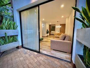 a living room with a sliding glass door with a couch at Nomadic Boutique Living and Experience Center in Medellín