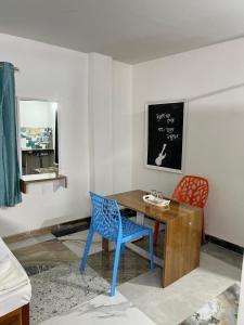 a room with a desk and two chairs and a chalkboard at swagatom Homestay in Jorhat