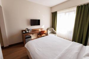 a hotel room with a bed and a desk and a window at TUNA OTEL in Gelibolu