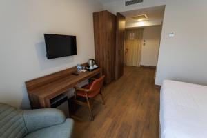 a hotel room with a bed and a desk with a television at TUNA OTEL in Gelibolu +38 photos