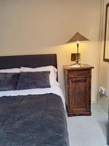 a bedroom with a bed and a lamp on a night stand at Eleni's Cottage in Apsiou