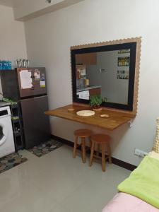 a kitchen with a mirror and a table and two stools at Aly's Home in Lapu Lapu City