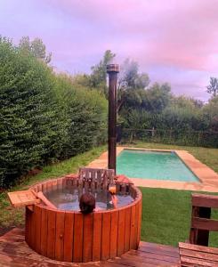 a hot tub with a person in it next to a pool at Cabaña Vista Las Bravas in Recinto