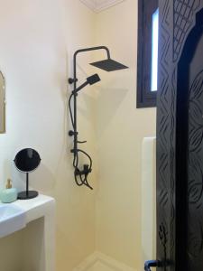 a bathroom with a black lamp next to a sink at Adrar Lodge - Boutique Guesthouse with Sea View in Tamraght Ouzdar