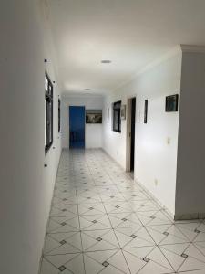 a hallway with white walls and a tile floor at PiscinasBar do Ramos in Conde