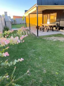 a park with a picnic table and flowers in the grass at Quinta para alquilar in Junín