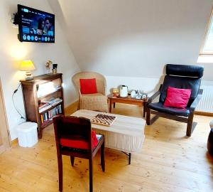 a living room with two chairs and a table at Ti Ar Skol, chambre d'hôtes in Huelgoat