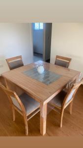 a wooden table with two chairs and a bowl on it at Quinta para alquilar in Junín