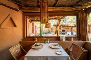 a dining room with a table and a window at Awasi Atacama in San Pedro de Atacama