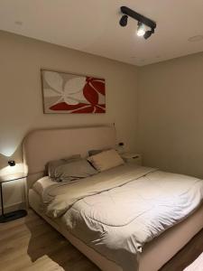 a bed in a bedroom with a painting on the wall at شقة غرفة وصالة in Al Khobar