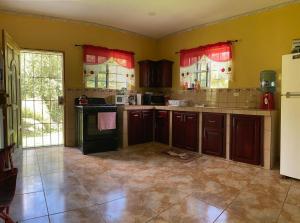 a large kitchen with brown cabinets and red windows at Royal Properties Link in Crooked Tree