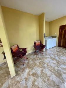 two chairs are sitting in a room with a tile floor at Royal Properties Link in Crooked Tree +6 photos
