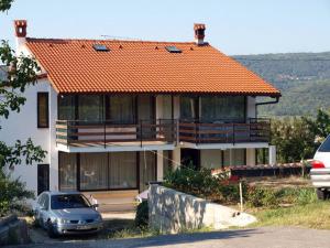 a house with an orange roof with a car parked in front at Apartment Nevenka in Pobegi