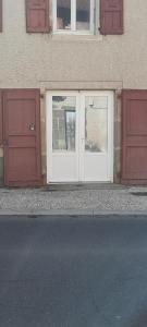 a pair of doors on a building with red doors at Studio sans chambre 2 personnes in Arsac-en-Velay