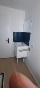 a bathroom with a white sink with a mirror at Studio sans chambre 2 personnes in Arsac-en-Velay