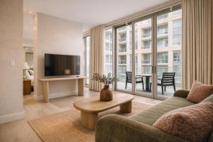 a living room with a couch and a tv and a table at Nester Finn Entertainment District in Toronto