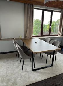 a table and chairs in a room with windows at Antwerp West Side Penthouse in 't Hoeksken
