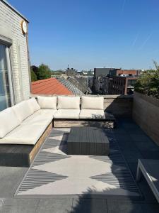 a white couch sitting on top of a roof at Antwerp West Side Penthouse in 't Hoeksken
