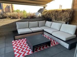 a couch and a coffee table on a patio at Antwerp West Side Penthouse in 't Hoeksken