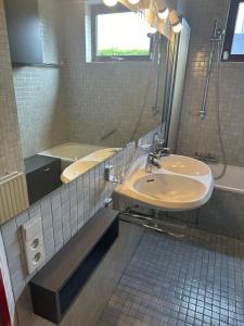 a bathroom with two sinks and a mirror and a tub at Antwerp West Side Penthouse in 't Hoeksken +2 photos