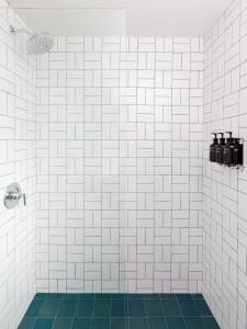 a white tiled shower with a green tile floor at Trailhead Lodge in Estes Park +35 photos