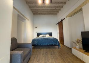 a bedroom with a bed and a couch and a tv at Suite Matlazinca by Casa Bravo in Toluca