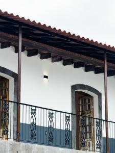 a white building with a balcony with two doors at Suite Matlazinca by Casa Bravo in Toluca