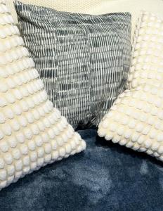 two white pillows sitting next to a gray pillow at Suite Matlazinca by Casa Bravo in Toluca