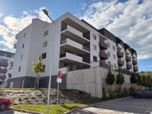 a white apartment building with a parking lot at home&stay - free parking in Trenčín