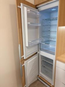 an empty refrigerator with its door open in a kitchen at home&stay - free parking in Trenčín