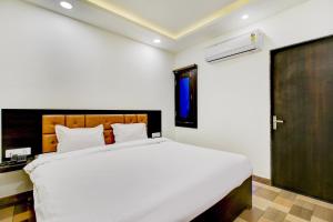 a bedroom with a large white bed and a window at Hotel O Bonsai in Bhopal +20 photos