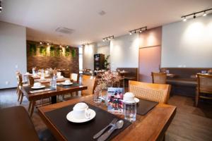 a dining room with wooden tables and chairs at H2 Platinum Lourdes in Belo Horizonte
