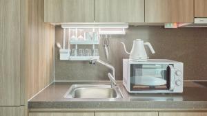 a kitchen counter with a sink and a microwave at Haeundae Elbonz in Busan +130 photos