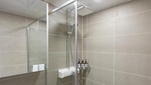a bathroom with a shower with bottles of wine at Haeundae Elbonz in Busan