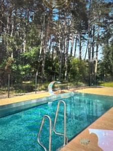 a swimming pool with a slide in front of some trees at Apartamenty Łukęcin Joy me 3 in Łukęcin