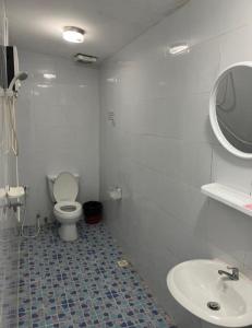 a white bathroom with a toilet and a sink at Reggaein in Phi Phi Islands