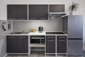 a kitchen with a stainless steel refrigerator and a microwave at Apartament Fantazja in Przemyśl