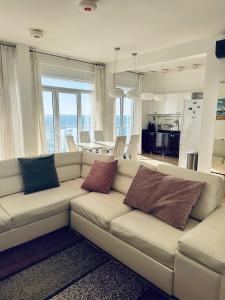 a living room with a white couch with two pillows at SF Apartments Lux in Dobra Voda