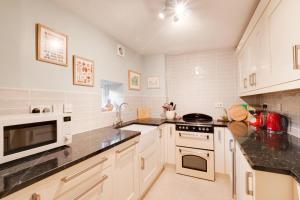 a kitchen with white appliances and black counter tops at 2 Bed in Askrigg oc-ds1019 in Askrigg