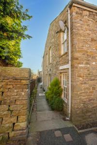 a stone house with a stone wall and a street at 2 Bed in Askrigg oc-ds1019 in Askrigg