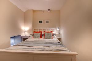 a bedroom with a bed with red pillows at 2 Bed in Askrigg oc-ds1019 in Askrigg +4 photos