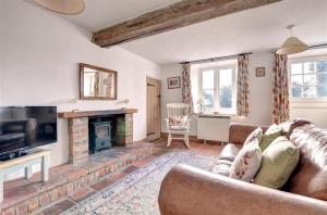 a living room with a couch and a fireplace at 2 Bed in Bodham oc-1660 in Bodham