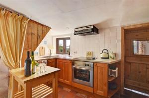 a kitchen with a stove and a table with wine glasses at 2 Bed in Bodham oc-1660 in Bodham