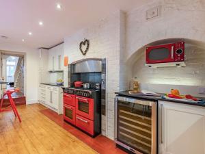 a kitchen with a red stove and a microwave at 5 Bed in Swanage oc-dc060 in Swanage