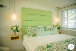 a bedroom with a bed with a green headboard at Gulfside Resort. Unit 10 in St. Pete Beach