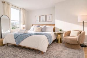 a bedroom with a large bed and a chair at Luxury Rooftop Pool & Dock Steps to Downtown in Annapolis