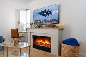 a living room with a fireplace with a tv over it at Luxury Rooftop Pool & Dock Steps to Downtown in Annapolis