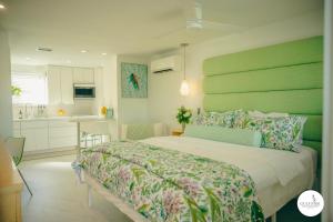 a bedroom with a large bed with a green headboard at Gulfside Resort. Unit 10 in St. Pete Beach